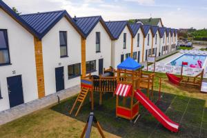 an apartment complex with a playground and a pool at Holiday homes with pool, close to the beach in Rewal