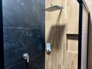 a shower stall with a wooden door with a sensor at Departamento la estación Tequila in Tequila