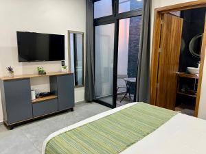 a bedroom with a bed and a television on a wall at Departamento la estación Tequila in Tequila