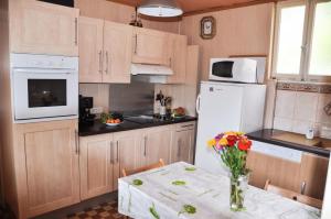 una cocina con una mesa con un jarrón de flores. en Gite du Walsbach, en Munster