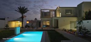 a house with a swimming pool in front of a house at Villa DEJRBA De LUXE in Houmt Souk
