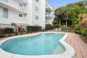 a swimming pool in front of a apartment building at Unit 2 Point Break in Yaroomba