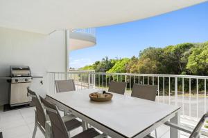 a white table and chairs on a balcony at Unit 2 Point Break in Yaroomba