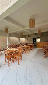 a dining room with wooden tables and chairs at VILA GAHERI Pousada Boutique com Piscina Privativa in São Miguel dos Milagres