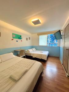 a hotel room with two beds and a window at Hotel Anauco in Bucaramanga