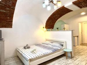 a bed in a room with a brick wall at Roxen Central Studio Sibiu in Sibiu