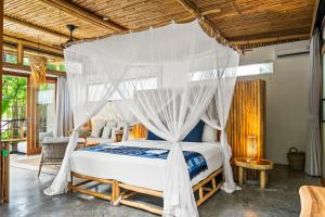 a bedroom with a bed with a canopy at Jellyfish Villas Bingin, Uluwatu in Uluwatu +33 photos