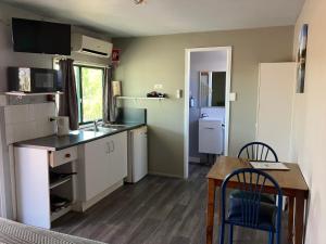 a small kitchen with a table and a dining room at Major Mitchell Caravan Park in Mitchell