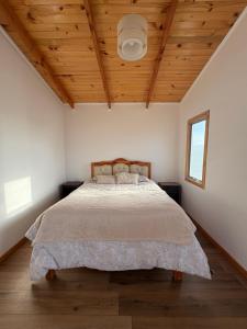 a bedroom with a bed with a wooden ceiling at Rincon del desierto lodge in Punta de Choros