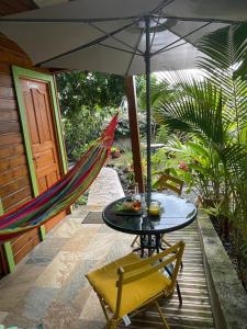 a patio with a hammock and a table and chairs at Casamango in Basse-Terre