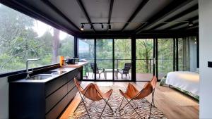 a room with a kitchen with a sink and two chairs at Cabaña en el Lago Cerca MetroCable ARVI in Guarne +60 photos