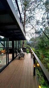 a porch of a house with a bench and trees at Cabaña en el Lago Cerca MetroCable ARVI in Guarne