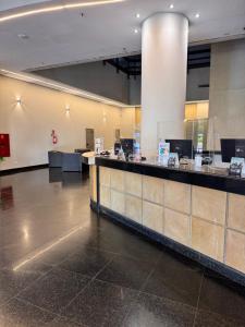 a lobby with a counter in a building at Luix Londrina Flat 505, 43 m2, QS, ar quente e frio, c garagem in Londrina +28 photos