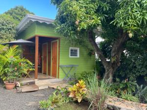 a green tiny house with a porch and a tree at Casamango in Basse-Terre +10 photos