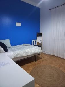a room with two beds and a blue wall at Blue House - two rooms in Almada