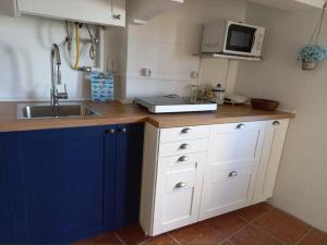 a kitchen with a sink and a microwave at Blue House - two rooms in Almada