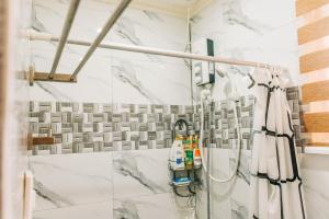 a shower in a bathroom with white marble tiles at Casa de Oro in Iyam +46 photos