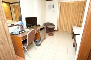a room with a desk with a computer and chairs at O Hotel in Bacolod