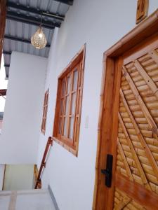 a wooden door and window in a white room at Fifi Shouse Ayangue in Santa Elena