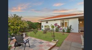 a house with a patio with a table and chairs at The Ducks Nest - Ocean Retreat in Safety Bay