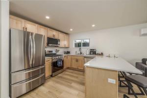 a kitchen with a stainless steel refrigerator and wooden cabinets at The Flats- Executive Suite-Downtown CDA in Coeur d'Alene