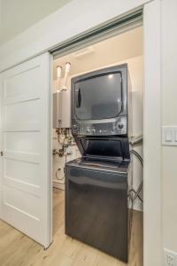 a kitchen with a microwave and a tv in a closet at The Flats- Executive Suite-Downtown CDA in Coeur d'Alene