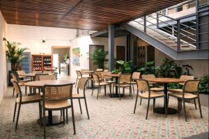 a restaurant with tables and chairs in a building at Capybara Hostel - Boutique hostel in Villavicencio