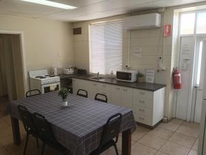 a kitchen with a table with chairs and a microwave at Accommodation @ Isa in Mount Isa