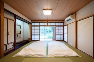 a large bed in a room with a window at villa itsutsu in Kamigotō