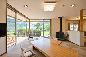 a living room with a fireplace and a wooden table at villa itsutsu in Kamigotō