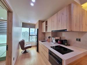 a kitchen with wooden cabinets and a chair in it at Little House Sea in Nha Trang