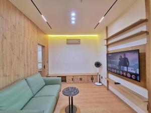 a living room with a couch and a projection screen at Little House Sea in Nha Trang