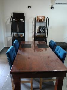 a wooden table with blue chairs in a room at Loft Moderno in Viedma