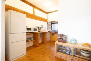 Eine Küche mit weißem Kühlschrank und Holzboden in der Unterkunft Vacation rental HIKE in Nirasaki