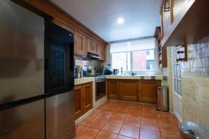 a large kitchen with wooden cabinets and a large window at Departamento 4 recamaras in Acapulco