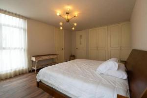a bedroom with a white bed and a chandelier at Departamento 4 recamaras in Acapulco