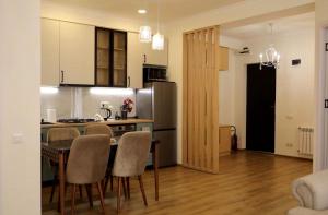 a kitchen with a table and chairs and a refrigerator at Stylish House in Kutaisi +31 photos