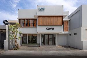 a white building with a coya sign on it at Cove Ruma Coliving in Denpasar