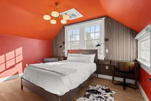 a bedroom with an orange wall and a bed at Assemble Boise in Boise