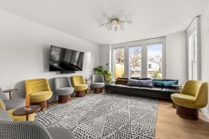 a living room with a couch and chairs and a tv at Assemble Boise in Boise