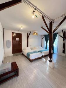 a bedroom with two beds and a tree in it at Villa Bari Loft in Setiu