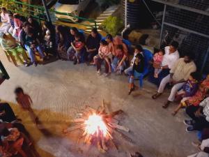 a group of people sitting around a fire pit at Wild Window - Forest View Homestay in Thekkady