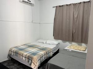 two beds in a small room with a window at Hotel Classic in Porangatu