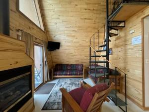 a living room with a staircase in a house at Cedar Cove Cabin 5 in Butternut