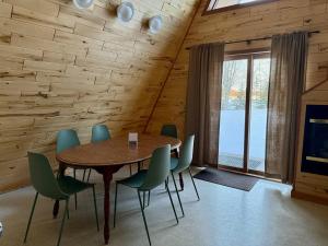 a dining room with a table and green chairs at Cedar Cove Cabin 5 in Butternut
