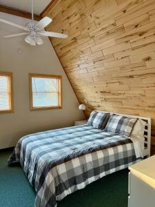 a bedroom with a bed with a wooden ceiling at Cedar Cove Cabin 5 in Butternut