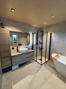 a bathroom with a tub and a toilet and a sink at Bausje Beach House in Farsund +74 photos