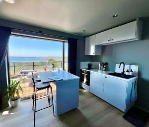 a kitchen with a table and a view of the ocean at Bausje Beach House in Farsund