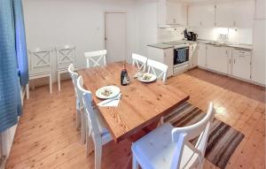 a kitchen with a wooden table and white chairs at Gorgeous Home In Blentarp With Wifi in Blentarp
