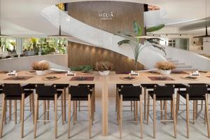 a dining room table with chairs and tables at Melia Lebreros in Seville